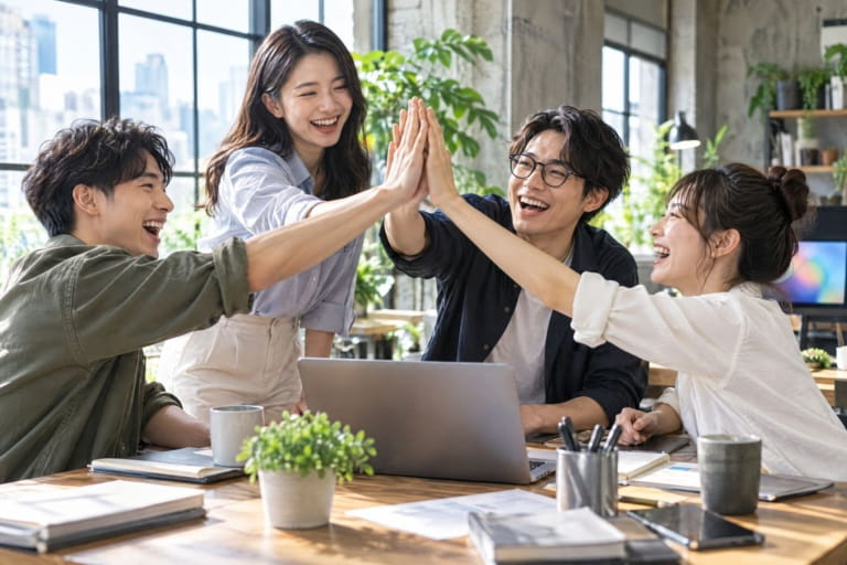 新創公司網站設計：新創團隊圍著筆電擊掌慶祝